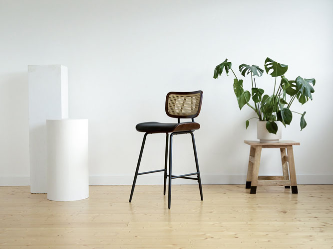 Cane counter stool beside a white plinth